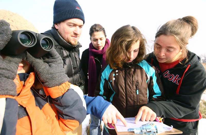 A group of kids gathered to look at a checklist of birds for the Christmas Bird Count for Kids