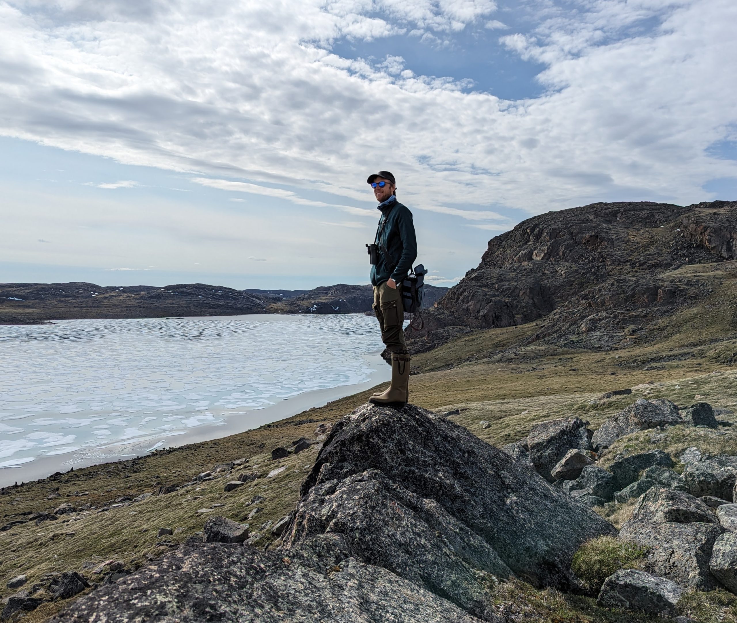 Alvan Buckley stands on a rock near the coastline.