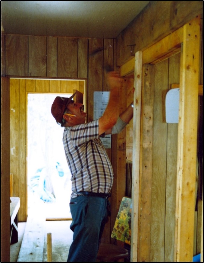 Doug Tarry hammers an overhead beam while building the Tip Point cabin in 1987.